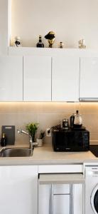 a kitchen with white cabinets and a sink and a microwave at La Casa Verde in Seoul +17 photos