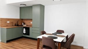 a kitchen and dining room with a table and chairs at Agel Inn Apartments Mavrovo in Mavrovo