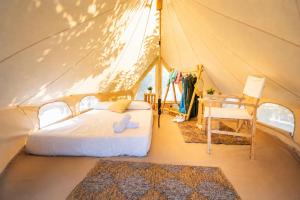 a bedroom in a tent with a bed and a chair at Kampaoh Bufones Pría in Garaña