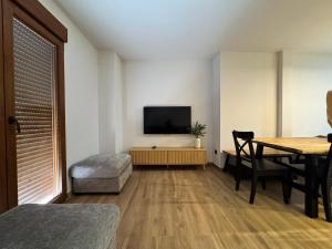 a living room with a table and a television at Casa Ara Montanejos in Montanejos