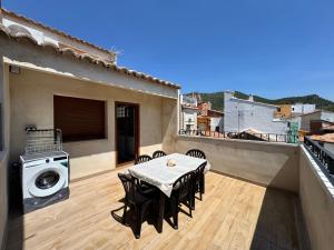 a patio with a table and a washing machine on a balcony at Casa Ara Montanejos in Montanejos