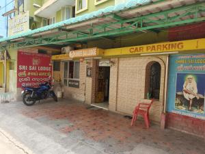 a motorcycle parked in front of a building with signs at Sri Sai Lodge in Palni
