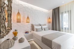 a white bedroom with a bed and a table at Naxian Pearl in Mikri Vigla