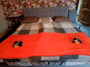 a bed with a red blanket on top of it at Ferme du Charme in Moustier