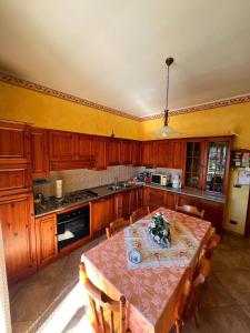 a kitchen with a table with chairs and a kitchen with yellow walls at Casa Vacanze PIAZZETTA in San Nico
