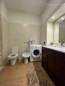 a bathroom with a toilet a sink and a washing machine at Casa Vacanze PIAZZETTA in San Nico