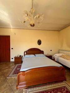 a bedroom with a large wooden bed and a chandelier at Casa Vacanze PIAZZETTA in San Nico
