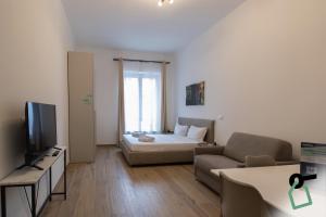 a living room with a bed and a couch at Collegno Cozy Apartments in Turin