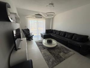 a living room with a black couch and a table at Serenity Apartment in Struga