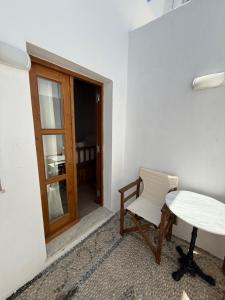 a white room with a table and a white chair at Apollino Lindos in Lindos