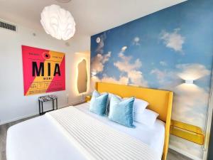 a bedroom with a white bed with a yellow headboard at Electric Luxury Downtown Bayfront Brickell in Miami
