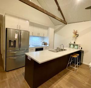 a kitchen with a stainless steel refrigerator and a sink at Overwater on the Murray in Murray Bridge