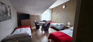 a room with two beds and a table and chairs at Willa Aura in Łeba