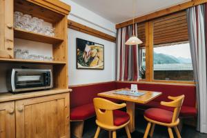 a dining room with a table and chairs and a microwave at Ferienresidenz Raich - Appartements mit Sky Wellness und Garten in Ried im Oberinntal