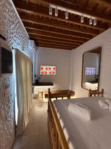 a bedroom with a bed and a mirror in a room at Apollino Lindos in Lindos +3 photos