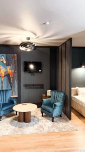 a living room with two chairs and a table and a bed at Villa Blanc in Bukovel