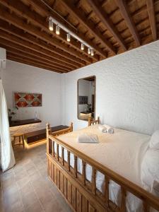 a bedroom with a bed and a mirror in a room at Apollino Lindos in Lindos