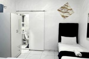 a small white room with a bed and a cabinet at Goshen Lodge Goodwood in Goodwood +152 photos