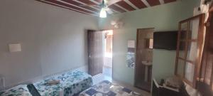 a bedroom with a bed and a ceiling fan at Vila Hibisco Pousada Saquarema in Saquarema