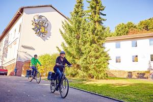 two people riding bikes in front of a building at DJH Jugendherberge Hagen in Hagen