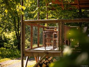 a wooden cage with a dog in it at Tiny house - Cabane sur pilotis - Etat Nature in Magnières