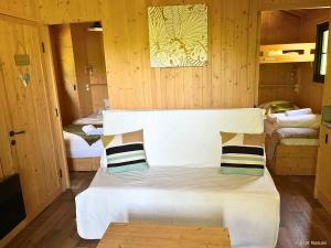 a small room with two beds and a white couch at Tiny house - Cabane sur pilotis - Etat Nature in Magnières +12 photos
