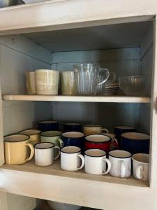 a shelf filled with different colored cups and bowls at Cal Mengo in La Vega