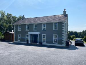 a large blue house with a car parked in front at Room Stay 4 in Corran Cross Roads