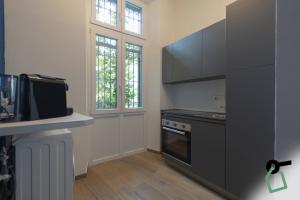 a kitchen with black cabinets and a stove at Collegno Cozy Apartments in Turin