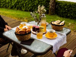 a table with baskets of bread and cups of coffee at Tiny house - Cabane sur pilotis - Etat Nature in Magnières