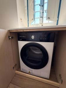 a washing machine in a cabinet in a room at Sliema Arch Suites Modern Boutique Apartment in St. Julianʼs