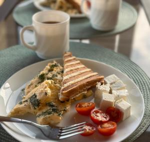 a plate of food with toast and tomatoes and a cup of coffee at Aqua Hotel in Bishkek