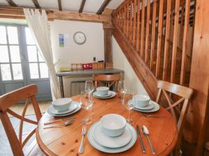 a wooden table with plates and wine glasses on it at Dewi Villa Apartment in Aberaeron +12 photos