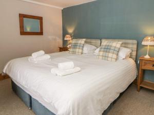 a bedroom with a large white bed with towels on it at Dewi Villa Apartment in Aberaeron