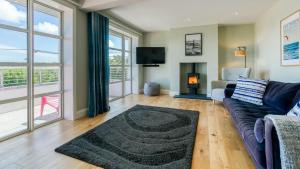 a living room with a couch and a fireplace at Glangors in Abersoch