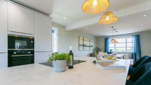 a kitchen and living room with a table and chairs at Glangors in Abersoch