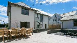 a patio with a table and chairs and a building at Glangors in Abersoch
