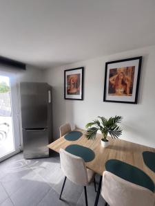 a kitchen with a wooden table and a refrigerator at Victoria II Parking GRATUIT in Boussu