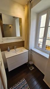 a bathroom with a sink and a mirror and a window at Maison Corcovado in Paray-le-Monial +41 photos