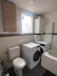 a small bathroom with a washing machine and a toilet at Victoria II Parking GRATUIT in Boussu +9 photos