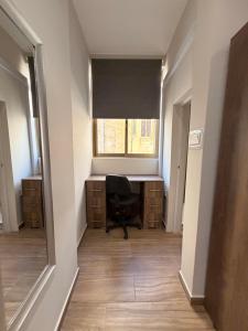 an empty hallway with a desk and a window at Sliema Arch Suites Modern Boutique Apartment in St. Julianʼs +3 photos