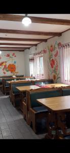a room with tables and chairs and flowers on the walls at Три підкови in Mykulychyn +8 photos
