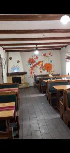 a room with tables and chairs and a painting on the wall at Три підкови in Mykulychyn