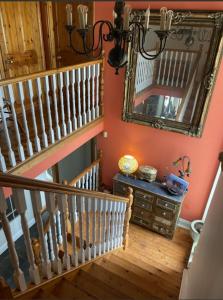 a hallway with a staircase with a mirror and a dresser at Room Two Stay in Corran Cross Roads