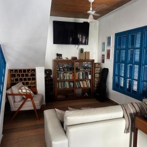 ein Wohnzimmer mit Sofa und Fernseher an der Wand in der Unterkunft Pousada Luz in Iriri
