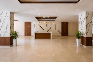 an empty lobby with a desk and two potted plants at Dimond Villa in Greater Noida