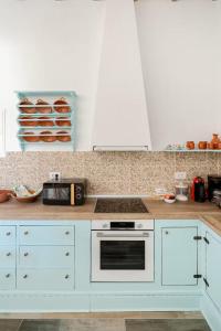 a kitchen with white cabinets and a stove top oven at Stefanis Relis House in Archangelos