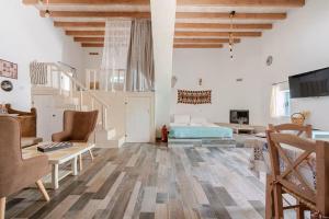 a living room with a staircase and a bed at Stefanis Relis House in Archangelos