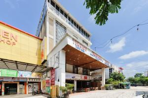 a building on a street with many shops at Urbanview Remington Hotel Palembang By RedDoorz in Palembang