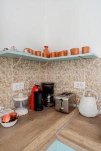 a kitchen with a counter top with pots on shelves at Stefanis Relis House in Archangelos +46 photos